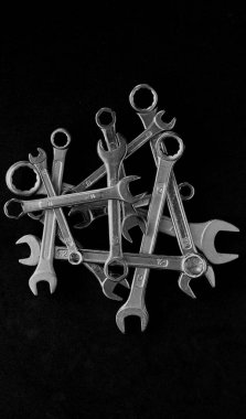 Dark Metal Spanners Siyah Yüzey Tek Renkli Stok Fotoğraflarında üst üste istiflenmiş