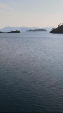 Yatı yatla görülebilen adalar arası su üzerinde uçan kamera dikey stok videosu 