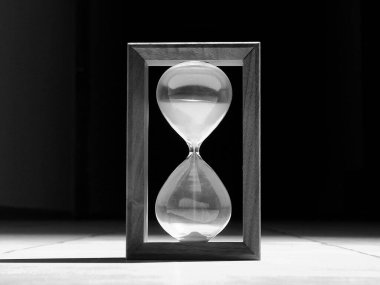 Vintage Time Glass With Flowing Sand Illuminated In Darkness Grayscale Stock Image  clipart
