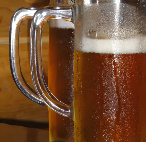 stock image Two cold steamed glasses with freshly brewed beer closeup view 