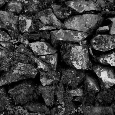 Antika duvarlara monte edilmiş eski taşlar. Siyah-beyaz kare fotoğraf.