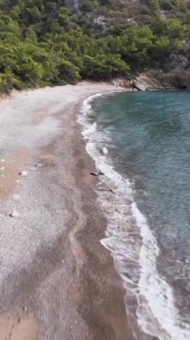 Yumuşak Dalgalar Üzerindeki Alçak Uçuş Güzel Çakıl Sahili Dikey Videosunda Sörf Yapıyor