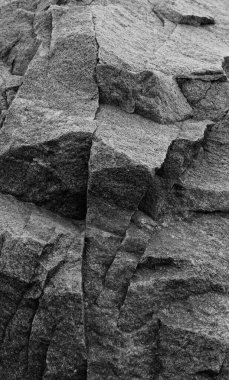 Vahşi granitin ham yüzeyinde kuvars içerikli çıkıntıların deseni. Koyu gri granit desen dikey görüntü