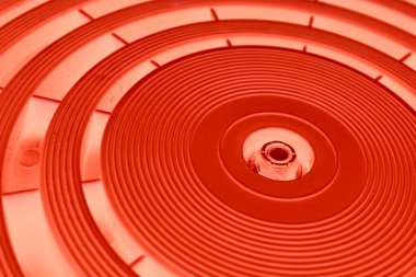 Kırmızı ışıklandırma açısı olan dairesel bir panelde değişken kalınlıktaki mükemmel eşmerkezli çemberler.