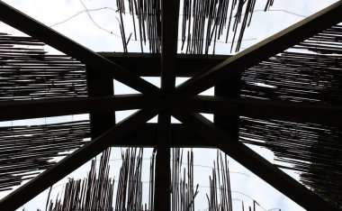 Roof beams of an open veranda partially covered with dry reeds clipart