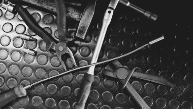 Antika, atölyedeki bir masanın üzerindeki zaman mekaniği aletleriyle karartılmış. Tamirci gri tonlu stok fotoğrafına aşina araçlar