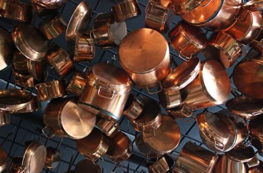 Mutfak çerçevesi, antika pirinç rengi tencere, tava ve yemek pişirme aletleriyle dolu.