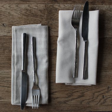 Antika masa üzerindeki çatal ve bıçaklar için el yapımı peçeteler sessiz renkler stok fotoğrafı