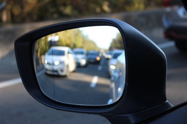 Otobanın dış aynası. Yavaşça hareket eden, odağını kaybetmiş arabalar. Yoğun trafik akışı nedeniyle otoyolda sınırlı hız