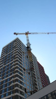 İnşaat bittikten sonra neredeyse tamamlanmış yüksek bir binaya yüksek irtifa vinci bağlanır.