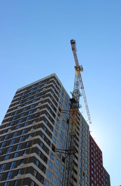 Kule inşaat vinci neredeyse bitmiş çok katlı apartman manzarası aşağıdan.