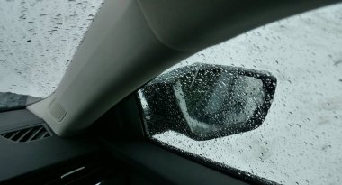 View from inside of a car on a drop pattern on the glass and snow on the side mirror. Car heater melting snow from car glasses after snowfall  clipart