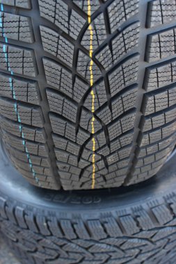 Bir araba lastiği asfaltta duran başka bir lastiğin kenarında durur. Lastik servisi stok resmi