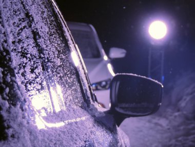 Kış Yolculuğunun Riskleri ve Özellikleri. Kar Tozlu Arabalar Yol kenarında, Sokak Işığının Altında Kötüleşen Hava Durumu Bekliyor