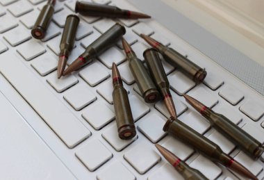 Laptop Klavyesinin Boş Anahtarları 'na serpiştirilmiş mermi kartuşlarının kavramsal fotoğrafı. Askeri Araştırma ve Savaş Stratejisi Kavramsal Görüntü 