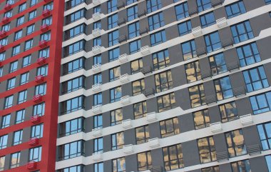 Boyanmış Gri ve Ucuz Apartman 'ın Kırmızı Yüzü. Dar Pencereli Konut Duvarı