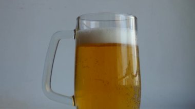 Rich Color Classic Beer 'ın Full Beer Tankard' ı ve 4K Çözünürlükte Cool Foam Level Video. Bir bardak biranın kalın duvarlarında kabarcıklar yükselir ve köpüklü bir kapanış videosu oluşturur.