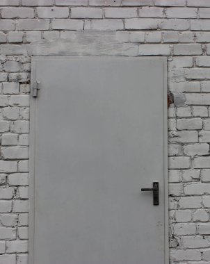 Sağlam çelik kapılı dikey arka plan tuğla işçiliğine sahip. Dikey Hikaye için Duvardaki Kapının Fotoğrafı