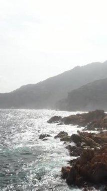 Akdeniz 'deki Rocky Adası' nın kıyılarında Sörf Dalgaları Dikey Hava Videosu