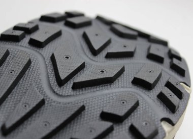 Beyaz arka plandaki tek yürüyüş ayakkabısı kalıbının ayrıntıları. Açık hava seyahati için geleneksel lastik ayakkabı deseni 