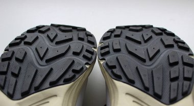 Damızlık bir yüzeyi ve detaylı bir manzarası olan siyah beyaz spor ayakkabıları. 