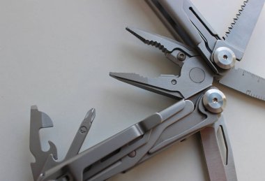 Beyaz Yüzey Yakından Bakış Aletinde Katlanmış Cep Çoklu Pense ve Bıçakları. Çoklu Amaç İçin Sıkıştırma Aracı