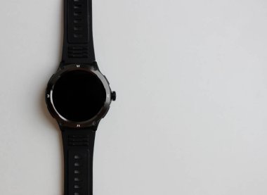 Siyah akıllı saat beyaz arkaplanda izole edilmiş. Görüntünün bir tarafında fotokopi alanı var. Kauçuk kayışlı modern saat 