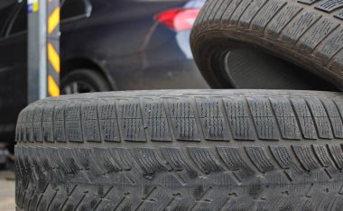 Araba tamirhanesinde lastik değiştirdikten sonra arabanın bagajına istiflenmiş eski lastikler. 