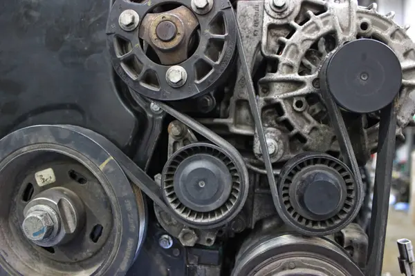 Benzin motorunun zamanlayıcı mekanizmasının tamirhanedeki tezgahta elden geçirilmesi. Araba motorundan sökülmüş. Tamir için bir kasada.