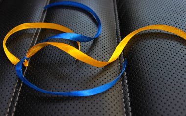 Üzerinde renkli tatil kurdeleleri olan koyu deri yüzeyin yakın plan fotoğrafı.