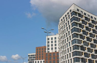 Sokak lambaları cadde boyunca uzanıyor ve yeni modern evler doluluk için hazırlanıyor. Çok Katlı Konut Bloklarının Geometrik Mimarisi