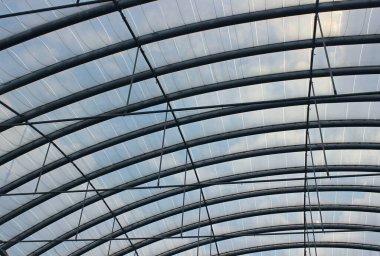Modern bir binanın cam kubbesini destekleyen metal kirişler.