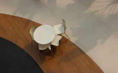 Kafede boş masa ve sandalyeler dekoratif zemin ve farklı kaplamalarla dolu.