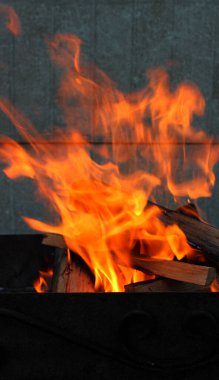 İçinde parlak bir alev bulunan metal brazier 'ın dikey fotoğrafı.