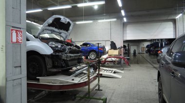 Çeşitli atölyeleri, araba asansörleri ve tamirhaneleri olan büyük bir araba tamir kompleksinin içi.