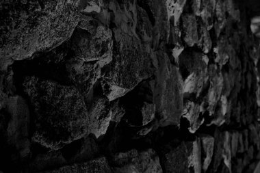 Muazzam bir karanlık duvarda pürüzsüz granit bloklar yumuşak bir odak ile uzaklığa doğru çekiliyor.