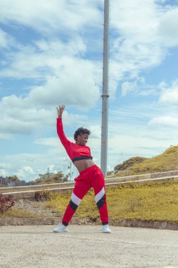 Jover mujer afro realiza baile estilo urban on parque local con hermoso y grande cielo y vejetaryen.