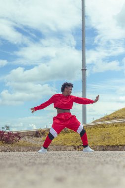 Jover mujer afro realiza baile estilo urban on parque local con hermoso y grande cielo y vejetaryen.