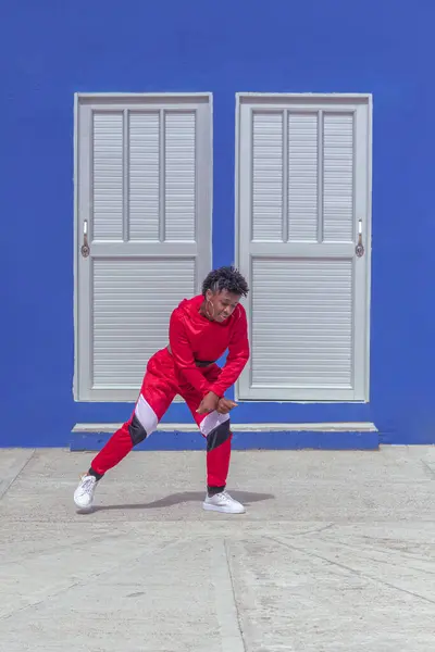 Jover mujer afro realiza baile estilo urban on parque local con save azul y puertas de fondo