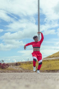 Jover mujer afro realiza baile estilo urban on parque local con hermoso y grande cielo y vejetaryen.