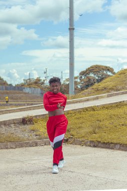 Jover mujer afro realiza baile estilo ruban in parque local con hermoso y grande cielo y vejetaryen.