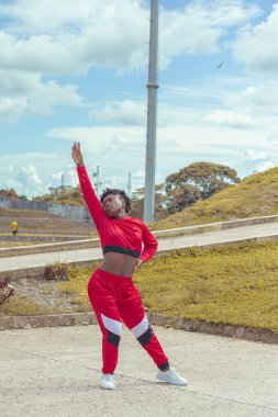 Jover mujer afro realiza baile estilo ruban in parque local con hermoso y grande cielo y vejetaryen.