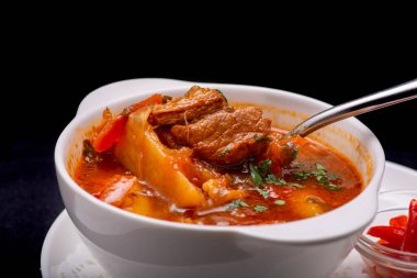 Beyaz kasede domates soslu et güveci.