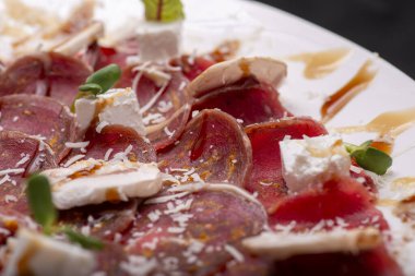 Dilimlenmiş etli carpaccio peynirli tabak