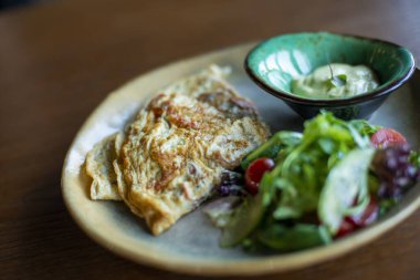 Yumurtalı kahvaltı, kızarmış somon, peynir, sebze ve salata.