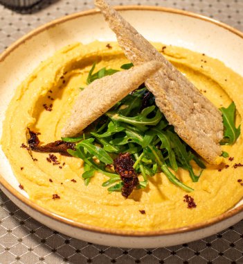 Beyaz tabakta biberiyeli kızarmış patates ve bir peçeteyle ahşap bir masa.