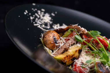 Siyah arka planda peynirli lezzetli ızgara sebzeler. Yakın çekim