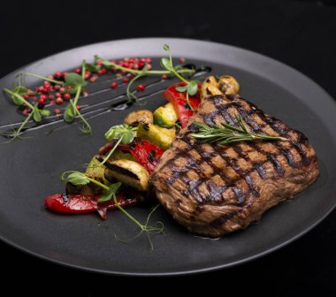 Siyah tabakta kuşkonmaz ile biftek.