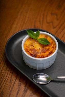 Siyah tabakta naneli ve dondurmalı lezzetli bir tatlının dikey yakın çekimi.