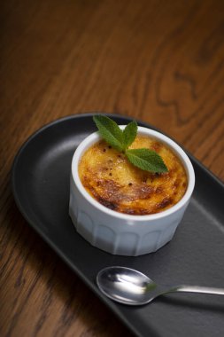 Lezzetli ev yapımı Lee Lee tatlısı. Vanilyalı krema, beyaz tabakta, ahşap masada.